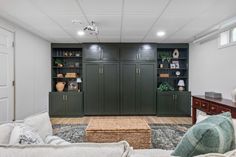 a living room filled with furniture and green cabinets