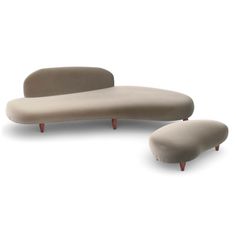 a white couch and footstool sitting next to each other in front of a white background