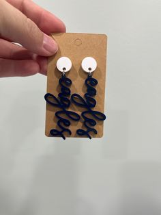 a pair of blue and white earrings with the word love written on them in cursive writing