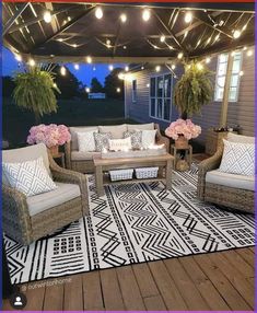 an outdoor living area with wicker furniture and string lights on the roof above it