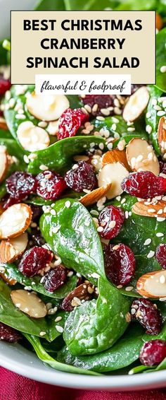 a white bowl filled with spinach and cranberry salad on top of a red cloth