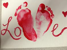 a hand and foot print on a piece of paper with hearts in the shape of love