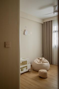 a white room with a dog bed on the floor and a cat house in the corner