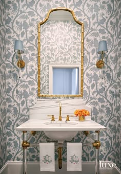 a white sink sitting under a mirror next to a wall mounted faucet in a bathroom