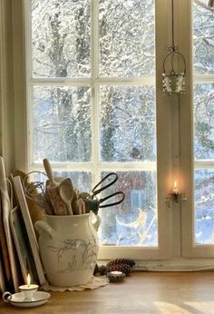 kitchen utensils are in a white bowl by the window