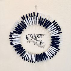 a wreath made out of toothpicks hanging on a wall with music logo in the middle