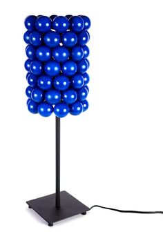 a lamp made out of blue balloons on a black stand