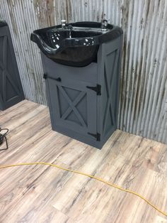 a black sink sitting on top of a wooden floor