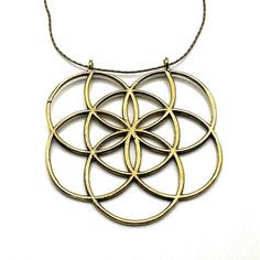 a gold necklace with four circles hanging from it's center, on a white background