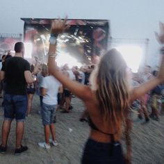 a group of people standing on top of a sandy beach next to a crowd of people