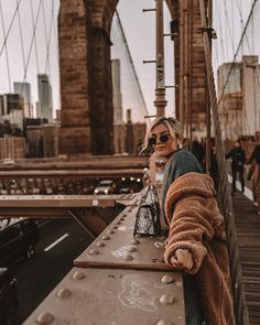 a woman standing on the side of a bridge