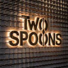 two spoons sign on the side of a building in front of a wall with lights