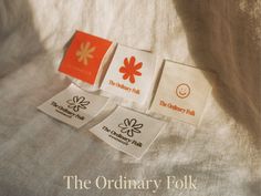 the ordinary folk logo is displayed on white fabric