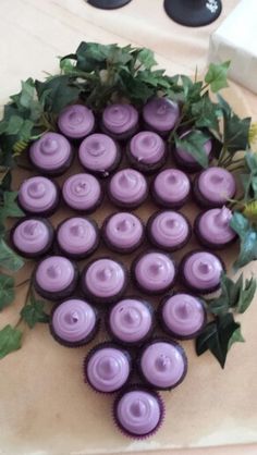 purple cupcakes are arranged in the shape of a wreath on top of a table