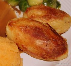 some food is on a white plate with broccoli and gravy in the background