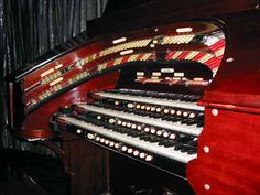 an old pipe organ with many strings and knobs on it's front side