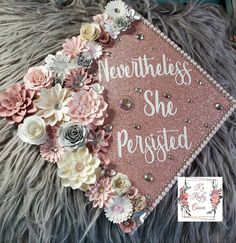 a graduation cap with flowers on it and the words, neverthress she presided