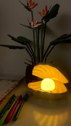 a yellow lamp sitting on top of a table next to some pens and markers in front of it