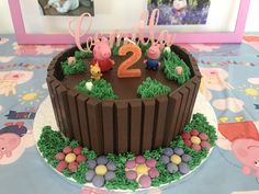 a birthday cake with peppa the pig and his number two on top is sitting on a table