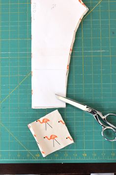 the scissors are next to some fabric and paper