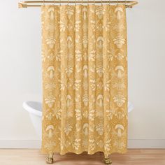 a yellow shower curtain with an ornate pattern on it and a white bathtub in the background