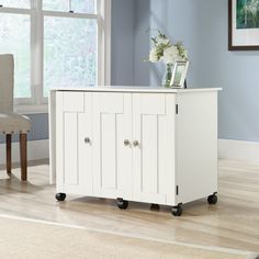 a white cabinet sitting on top of a hard wood floor