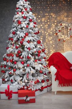 a white christmas tree with red and silver ornaments