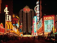 the las vegas strip is lit up at night with neon signs and casino buildings in the background