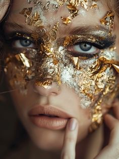 a woman with gold and silver makeup on her face