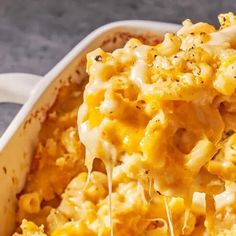 macaroni and cheese being lifted from a casserole dish