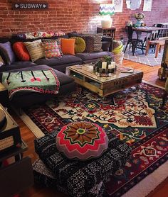 a living room filled with lots of furniture and decor on top of a wooden floor