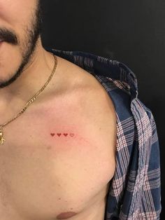 a man with a tiny heart tattoo on his chest