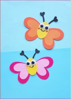 two paper butterflies with googly eyes on blue and pink background