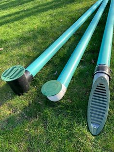 three different types of water pipes laying in the grass