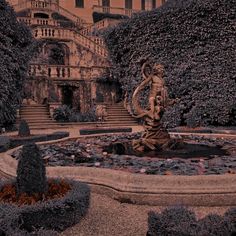 a fountain in the middle of a formal garden