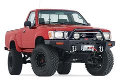 a red truck with big tires on it's flatbed is parked in front of a white background