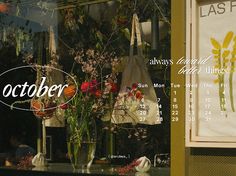 an advertisement for a flower shop with flowers in vases on the window sill