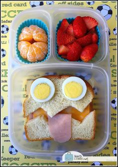 a plastic container filled with food and two eggs in the shape of an owl's face