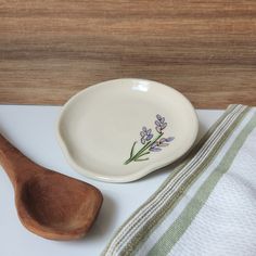 a wooden spoon sitting on top of a white counter next to a bowl and towel