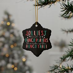 a christmas ornament hanging from a tree with the words jolliest and bunco plates underneath it