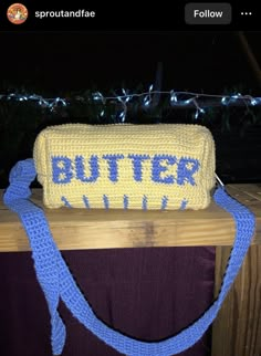 a yellow and blue purse sitting on top of a wooden table next to a string of lights