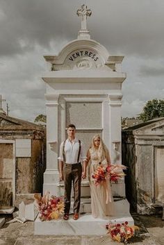 a man and woman standing in front of a grave