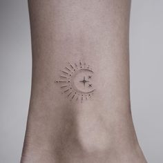 a small sun tattoo on the ankle