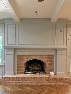 an empty room with a brick fireplace and wood floors