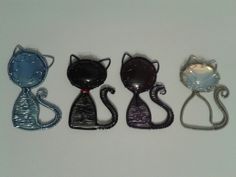 three metal cat brooches sitting next to each other