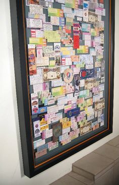 a wall covered in lots of different types of papers and magnets on it's side