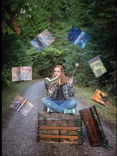 a woman sitting on top of a wooden crate holding a book and wands in her hand