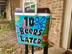 a sign that says 10 beers later in front of a brick building with flowers on it