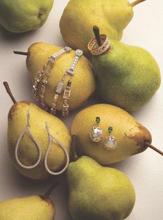 pears and other jewelry are arranged on a white surface