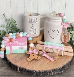 two mugs and some cookies are on a wooden table next to other items that include gingerbread, sugar and spice